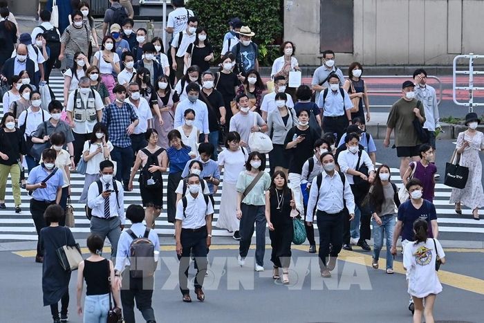 Người dân di chuyển trên phố ở Tokyo, Nhật Bản. Ảnh: AFP/TTXVN