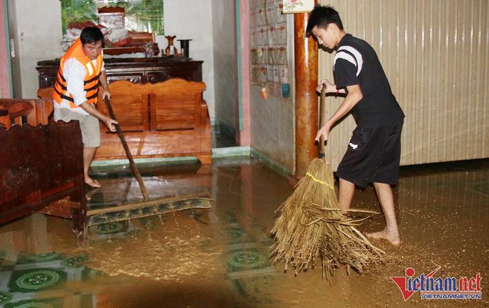 Dọn dẹp bùn đất sau khi nước lũ vừa rút - Ảnh: Trần Tuyên
