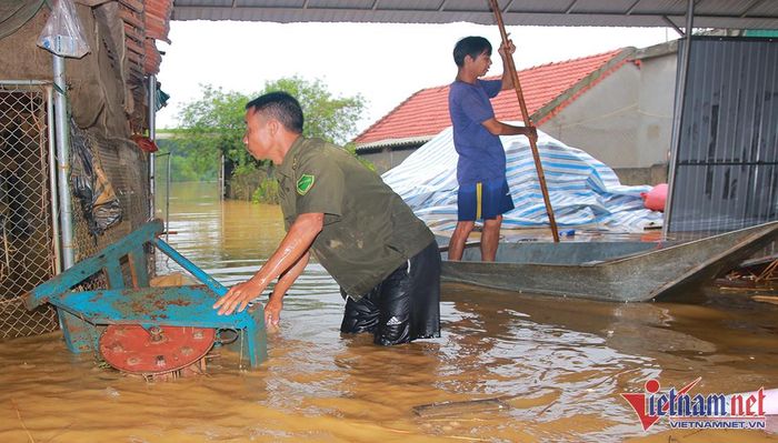 Lượm lặt tài sản bị ngập sâu trong nước - Ảnh: Trần Tuyên