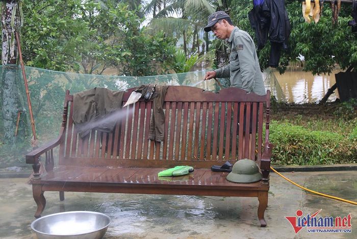 Các hộ dân luân phiên mượn phát điện, máy bơm nước xịt rửa bùn đất - Ảnh: Trần Tuyên