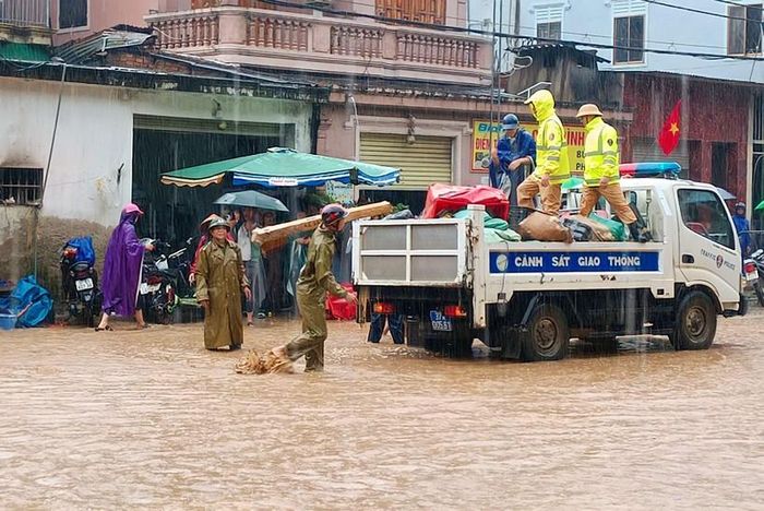 Lực lượng CSGT huyện Kỳ Sơn hỗ trợ người dân di chuyển đồ đạc đến nơi an toàn.