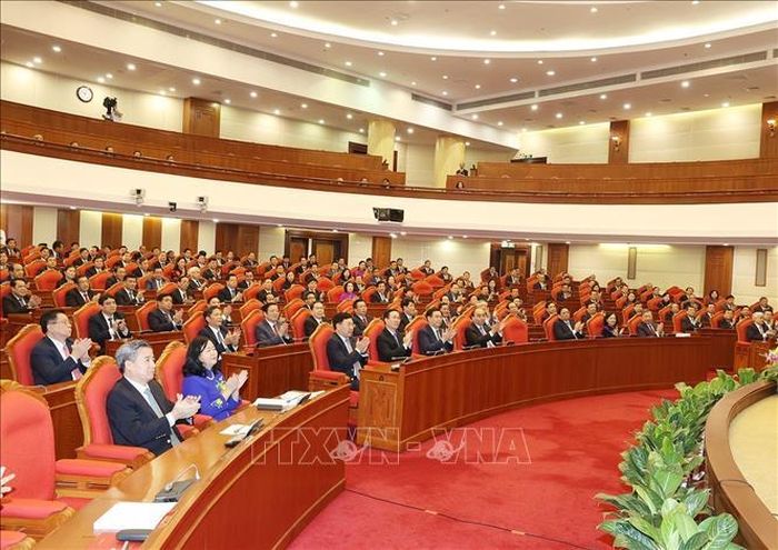 Các đồng chí lãnh đạo Đảng, Nhà nước và các đại biểu biểu quyết thông qua Nghị quyết Hội nghị. Ảnh: Trí Dũng/TTXVN.