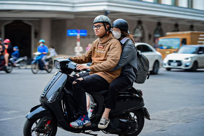 Người dân Hà Nội co ro chạy đi xe máy .