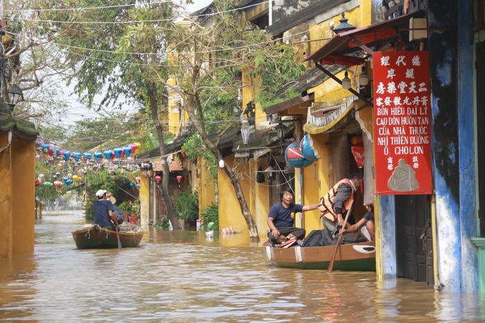Người dân dùng ghe nhỏ để di chuyển ra khỏi nơi ngập sâu