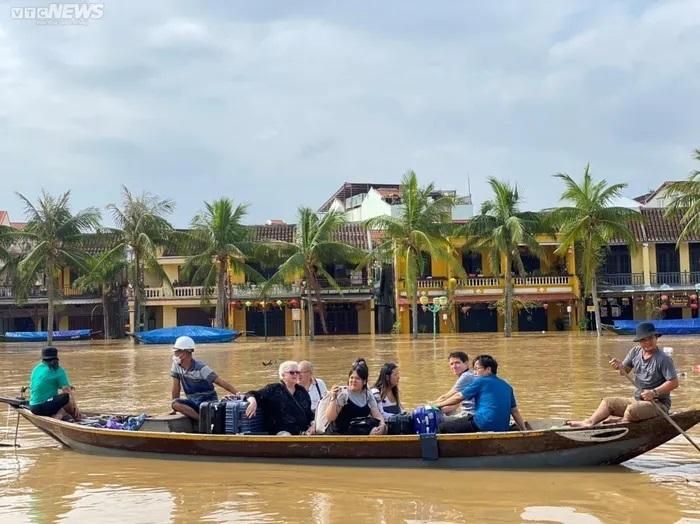 Nhóm du khách nước ngoài sơ tán khi khu lưu trú của họ bên An Hội bị ngập sâu. Ảnh: VTCnews
