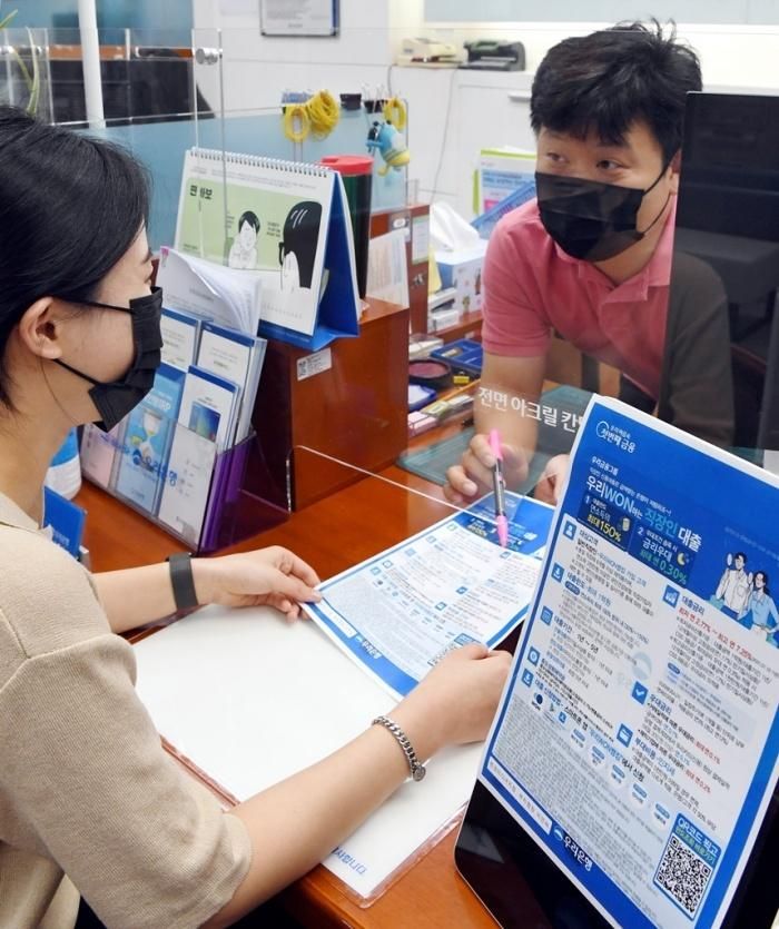  Một nhân viên văn phòng hỏi thông tin về các khoản vay cá nhân tại một ngân hàng tư nhân ở Seoul. Ảnh: KED. 