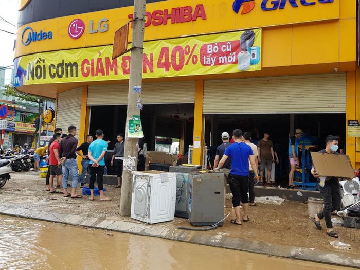 Trên khắp các tuyến đường, người dân, nhân viên các cửa hàng bắt đầu di dời tài sản bị ngập trong lũ.