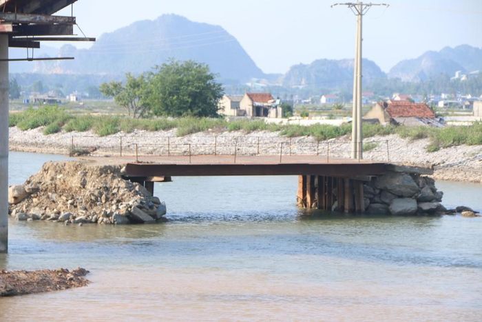 Vào tối 16/10, Ban Chỉ huy Phòng chống thiên tai, tìm kiếm cứu nạn và Phòng thủ dân sự tỉnh Nghệ An đã có Công điện 11/CĐ-BCH, yêu cầu các địa phương, ban, ngành phải tích cực, chủ động ứng phó diễn biến của bão số 6. Vậy nhưng, các địa điểm trên sông Hoàng Mai, kênh Nhà Lê vẫn chưa được thanh thải hết. (Trong ảnh: Chiếc cầu tạm với 2 trụ cầu bằng đá, bê tông vẫn còn nằm chình ình giữa dòng kênh Nhà Lê). Ảnh: Tiến Đông
