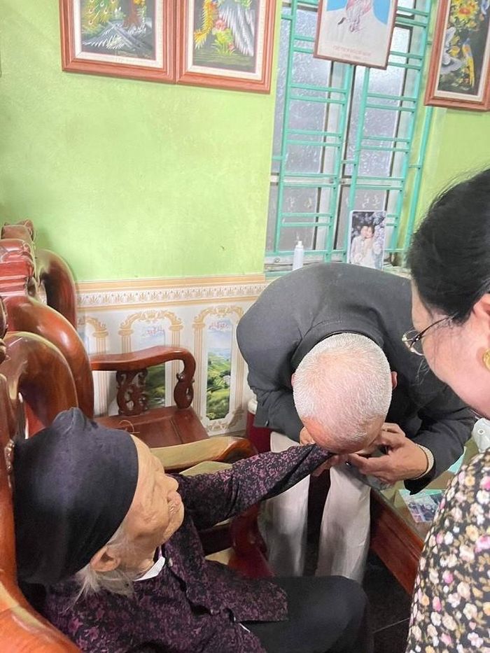 Ông Ahmed nâng tay người mẹ 83 tuổi hôn cảm tạ người sinh thành.