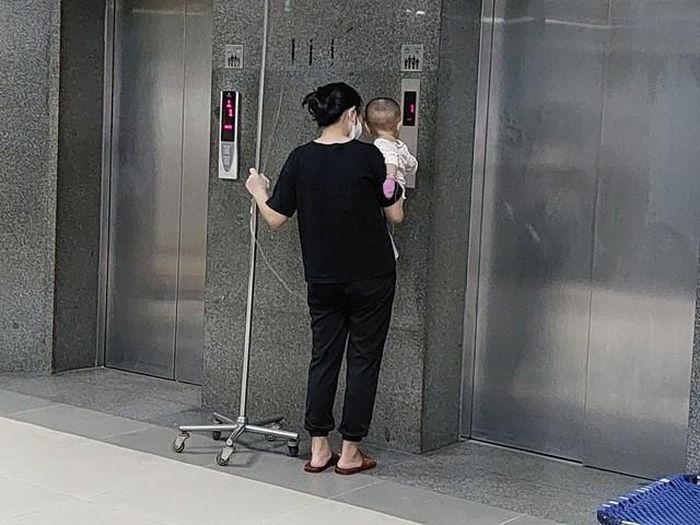 Đứa con nhỏ quấy khóc liên tục, khiến người mẹ trẻ phải rong ruổi khắp hành lang để dỗ dành.