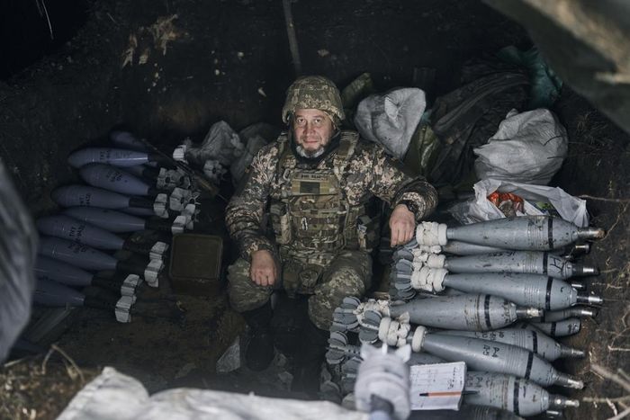 Binh sĩ Ukraine ngồi bên đống đạn pháo được chuẩn bị để tấn công ở Bakhmut, vùng Donetsk, ngày 21/10/2022. Ảnh: AP