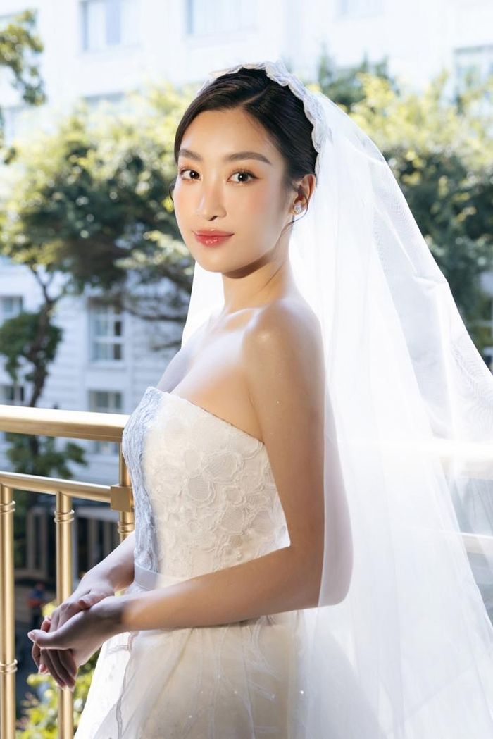 Hoa hậu Việt Nam 2016 diện váy trắng cúp ngực, phối ren cùng lối trang điểm nhẹ nhàng, tóc túm gọn phía sau nền nã trong ngày trọng đại.