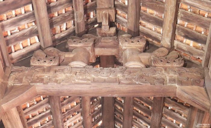 Trên các vì nhà, đặc biệt là những vì giữa, các kết cấu gỗ như rường, đấu, cột kê... đều được điêu khắc, chạm trổ với hình ảnh hoa lá, mặt hổ phù cách điệu khá sinh động. Ảnh: Huy Thư