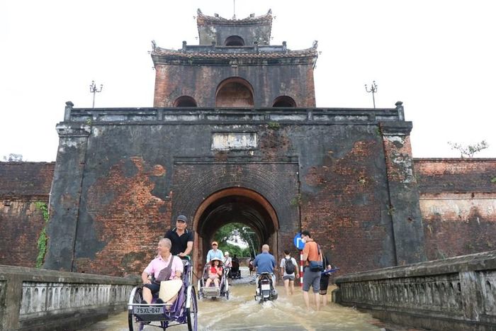 Du khách lựa chọn phương tiện xích lô để di chuyển trên những tuyến đường ở thành phố Huế vào mùa mưa. (Ảnh: Đỗ Trưởng/TTXVN)