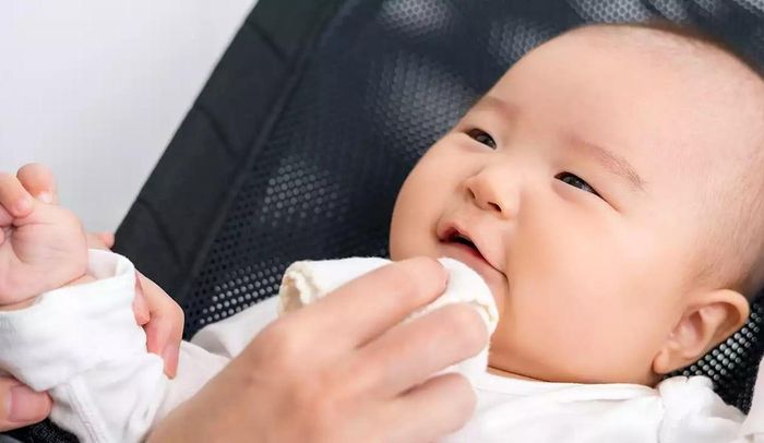 Việc lau nước dãi trên da bé để da sạch sẽ, khô ráo giúp ngăn ngừa tình trạng phát ban do mọc răng. Ảnh: Headtopics. 