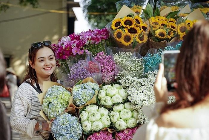  Các bạn trẻ chụp ảnh chung với xe hoa rực rỡ sắc màu. (Ảnh: Khánh Hòa/TTXVN) 