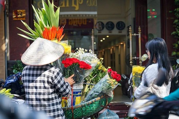  Mua hoa bán rong là một thói quen của người Hà Nội. (Ảnh: Khánh Hòa/TTXVN) 