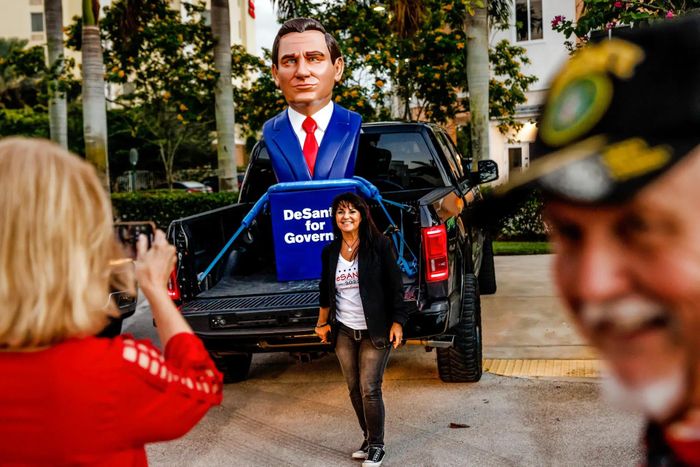 Người ủng hộ chụp ảnh cạnh bức tượng Thống đốc Ron DeSantis ở Coconut Creek, Florida. Ảnh: New York Times.