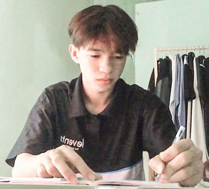  Trần Hữu Cường tranh thủ học bài sau những giờ làm thêm - Ảnh: NVCC 