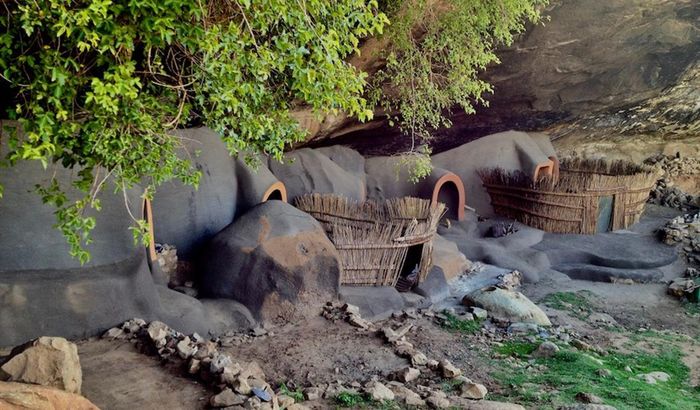 Bên trong hang động có những vật dụng cơ bản gồm chậu, xô nhựa để đựng nước và da bò để làm giường.