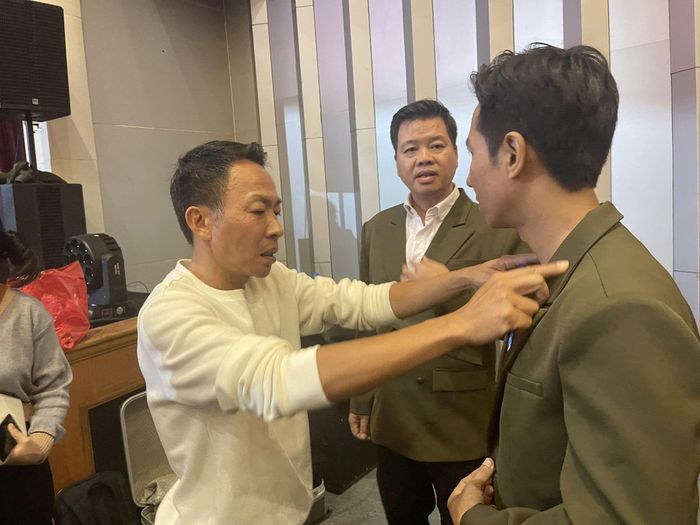 NSƯT Việt Hoàn chỉnh trang phục cho Lê Anh Dũng. 