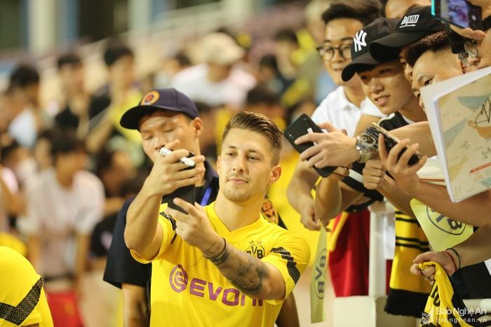  Do nhiều trụ cột của Dortmund tham dự World Cup 2022 nên HLV Edin Terzic trao cơ hội cho các cầu thủ trẻ ở chuyến du đấu châu Á, trong đó có trận đọ sức với tuyển Việt Nam. Thuyền trưởng Dortmund cho biết đây là cơ hội để các cầu thủ thể hiện bản thân mình. Trong ảnh: Sau buổi tập các cầu thủ Dortmund ra giao lưu với khán giả. Ảnh: Hải Hoàng
