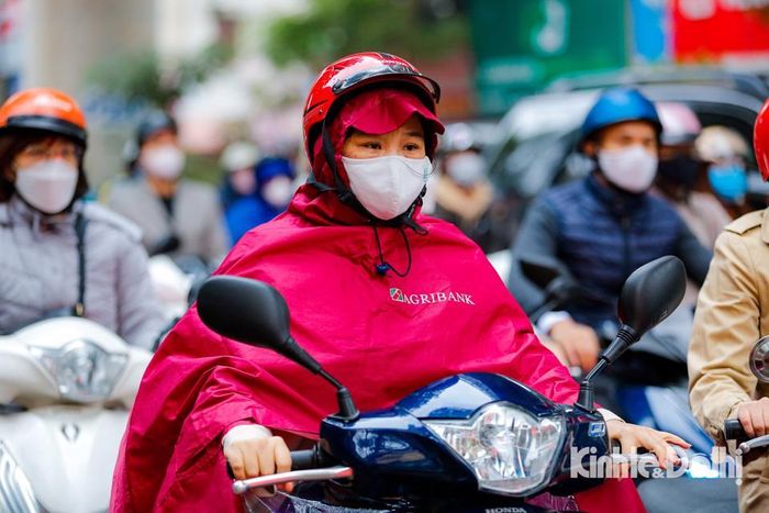 Người dân phải ra đường từ sáng sớm co ro trong những chiếc áo ấm dày, khăn len, mũ len và cả áo mưa mặc kín mít để giữ ấm.
