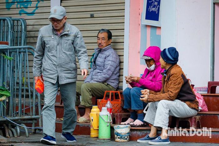 Người dân co ro uống chén trà nóng bên vỉa đường.