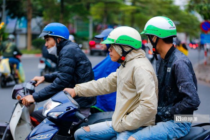 Người dân co ro điều khiển xe máy trong ngày đầu tiên Thủ đô Hà Nội chuyển rét đậm.