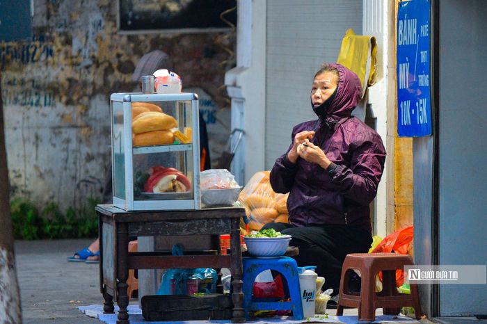 Nhiều người lao động phải mặc thêm áo mưa để tránh rét.