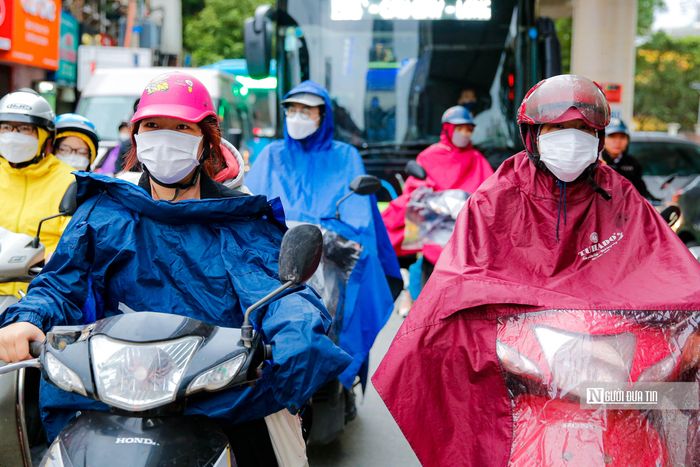 Những chiếc áo mưa không chỉ giúp người đi đường tránh mưa mà còn giảm cái lạnh do nhiệt độ xuống thấp.