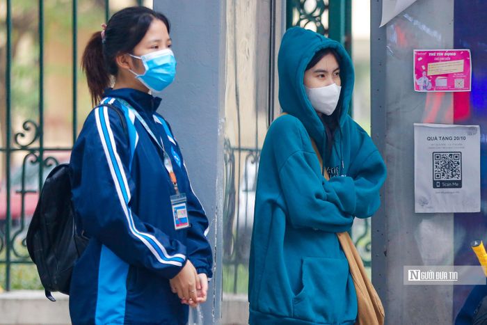 Sinh viên đứng co ro tại một điểm chờ xe buýt.