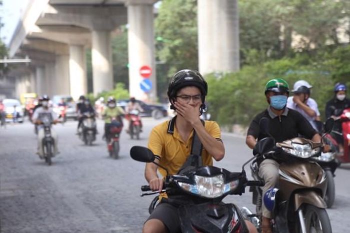 Người dân di chuyển trong khói bụi trên đường Xuân Thủy.