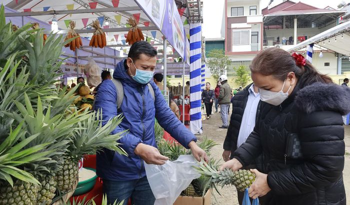 Người tiêu dùng mua quả dứa tươi tại gian hàng xã Bản Cầm, huyện Bảo Thắng.