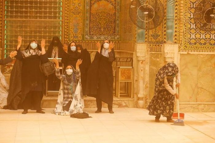 Những người phụ nữ trong cơn bão cát tại Đền thờ Imam Ali ở Najaf, Iraq, ngày 23/5. (Ảnh: REUTERS)