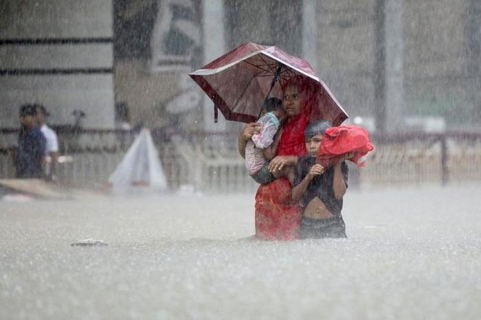 Mọi người lội qua dòng nước để tìm nơi trú ẩn trong trận lũ, giữa những trận mưa lớn gây lũ lụt trên diện rộng ở Sylhet, Bangladesh, ngày 18/6. (Ảnh: REUTERS)