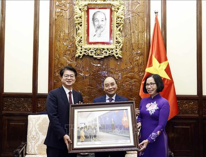Tổng Giám đốc TTXVN Vũ Việt Trang tặng Chủ tịch nước Nguyễn Xuân Phúc bức ảnh các đại biểu Việt Nam và Hàn Quốc tham quan Triển lãm "30 năm Hợp tác Việt Nam - Hàn Quốc" sáng 14/12/2022 tại Hà Nội.