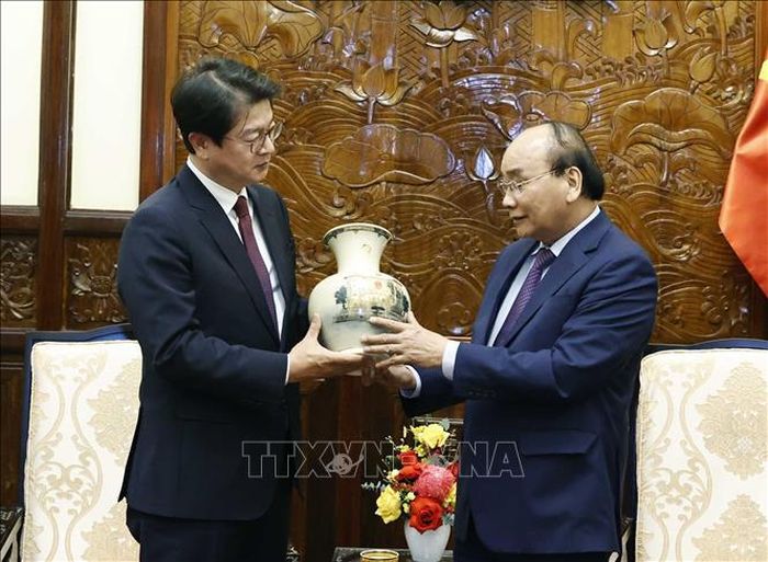 Chủ tịch nước Nguyễn Xuân Phúc tặng quà lưu niệm cho Chủ tịch, Giám đốc điều hành Hãng Thông tấn Yonhap Seong Ghi-hong.