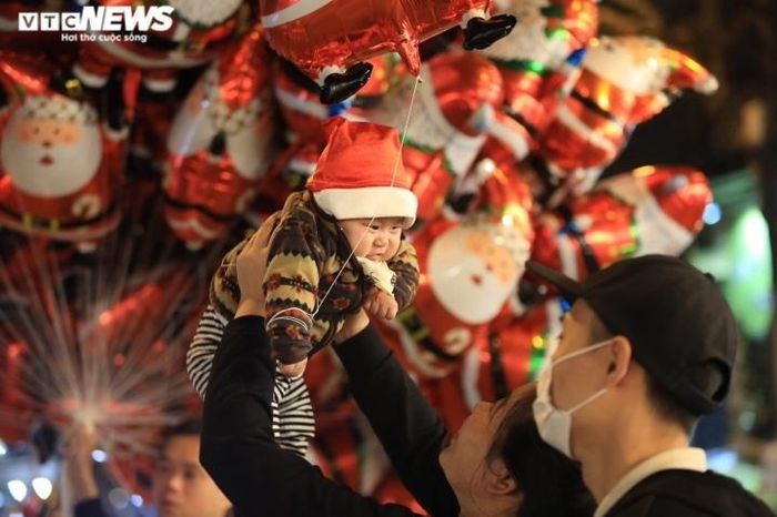 "Ông già Noel nhí" cũng hòa vào dòng người vui chơi, thưởng thức đêm Noel ấm áp.