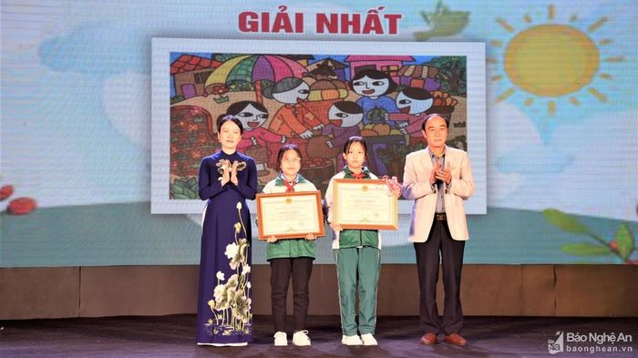 Bà Trần Thị Mỹ Hạnh - Ủy viên Ban Chấp hành Đảng bộ tỉnh và ông Trần Quốc Khánh - Phó trưởng Ban Tuyên giáo Tỉnh ủy trao giải Nhất cho các tác giả. Ảnh: Minh Quân