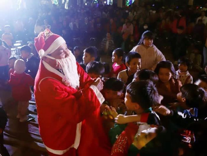 Ông già Noel trao quà cho các cháu. Ảnh: Hoàng Hùng – TTXVN