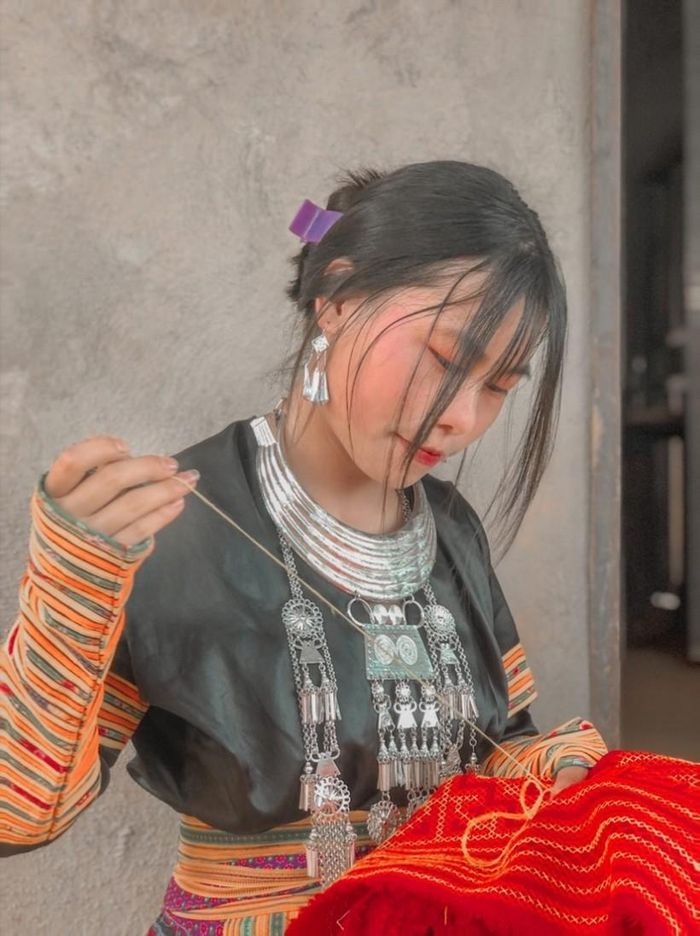 Mùa Thị May đang may trang phục truyền thống của dân tộc mình. Ảnh NVCC.