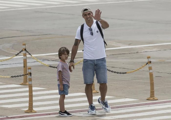 Suarez dắt theo cậu con trai nhỏ vẫy tay chào mọi người. ẢNH: AFP