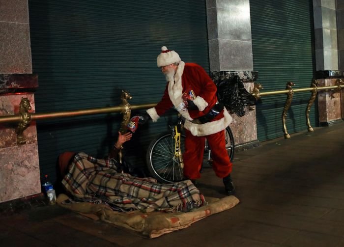  Trong trang phục ông già Noel, ông Federico Vieira Jasso, 64 tuổi, phát quà cho một người vô gia cư gần quảng trường Zocalo, thủ đô Mexico City, Mexico. 