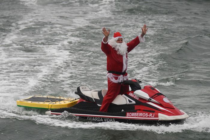  Một nhân viên cứu hộ trong trang phục ông già Noel cưỡi canô tại bãi biển Copacabana, thành phố Rio de Janeiro, Brazil. 