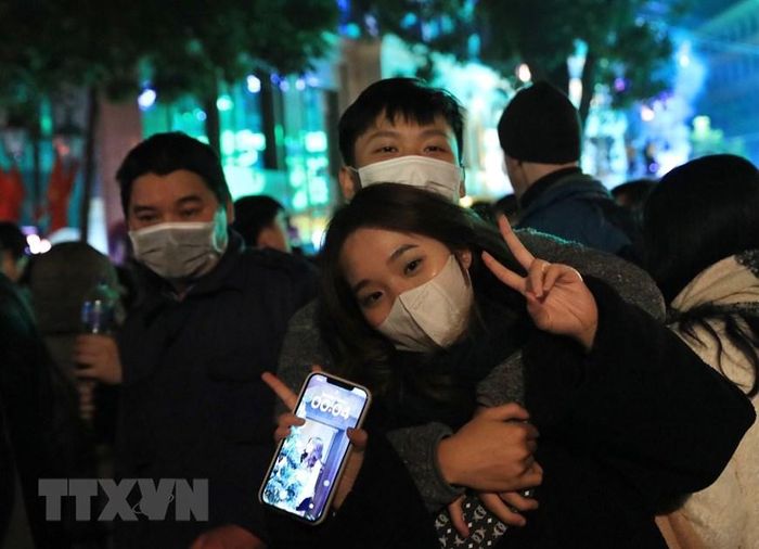 Một đôi bạn trẻ trong những phút giây đầu tiên của Năm mới 2023. (Ảnh: Hoàng Hiếu/TTXVN)
