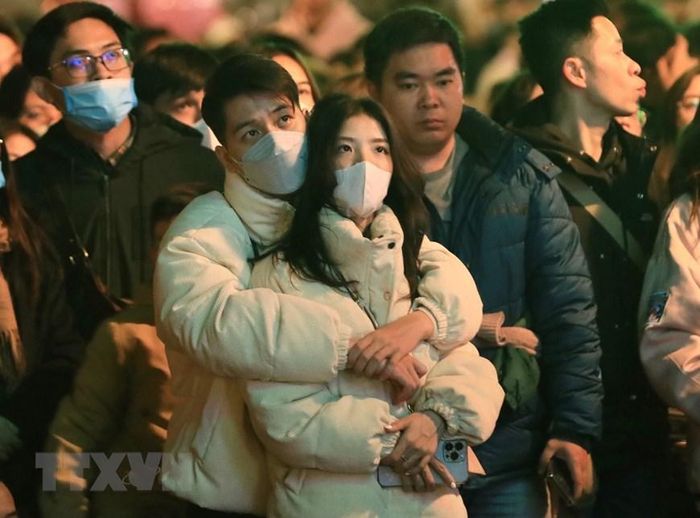 Người dân đón chờ giây phút đón mừng Năm mới 2023. (Ảnh: Hoàng Hiếu/TXVN)