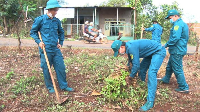 Lực lượng dân quân tự vệ các xã, thị trấn tham gia dọn dẹp vệ sinh đường làng, ngõ xóm, thu gom rác thải. Ảnh: Quang Tấn