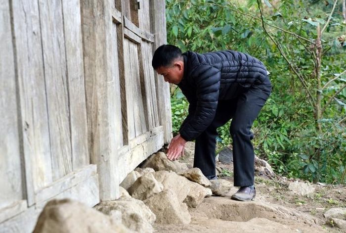 Khi thì nhặt từng viên đá, bịt những lỗ sạt ở chân tường.