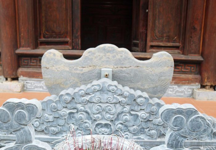 Tại nhà thờ họ Nguyễn Hữu còn lưu giữ nhiều hiện vật cổ kính như hương án, long ngai, lư hương đá, câu đối, đại tự... Trước thềm, gian giữa nhà thượng đường bài trí 1 chiếc khánh đá cổ. Khánh dài khoảng 0,8 m, trên khánh trang trí hoa văn sống động. Ảnh: Huy Thư